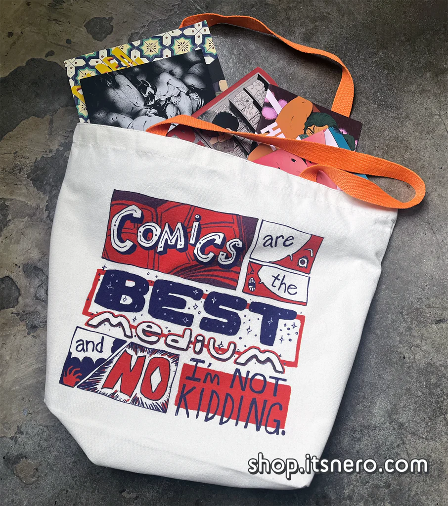 A photograph of a tote bag on the ground with books inside. The design says: Comics are the best medium and no I'm not kidding.